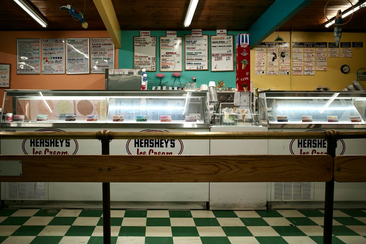 Bancone vuoto di una gelateria con menu colorati e vetrine.